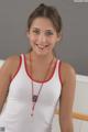 A woman in a white tank top with a red necklace.