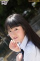 A young woman in a school uniform posing for a picture.