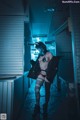 A woman in a black outfit is walking down a hallway.