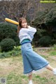 A woman holding a baseball bat in a field.